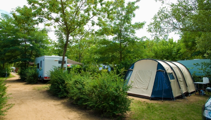 Shaded pitch for tents and motorhomes at Lake Cormoranche **** campsite, in the Auvergne-Rhône-Alpes region of France