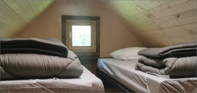 Das Schlafzimmer mit 2 Betten und das Lodge-Zelt, zur Vermietung auf dem Campingplatz Lac Cormoranche **** südlich von Mâcon