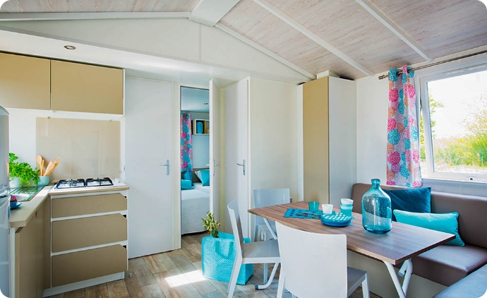 Küche und Wohnbereich des 2-Zimmer-Mobilheims im Departement Ain, zu mieten auf dem Campingplatz **** du Lac Cormoranche